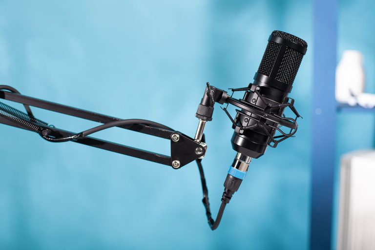 Black microphone on a blue background, symbolizing our ad-based services.